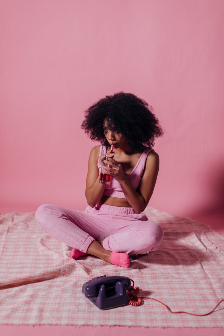 Woman In Pink Crop Top And Jogging Pants Drinking