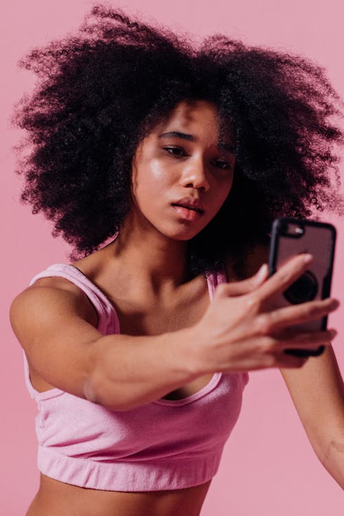 Free Woman in Pink Crop Top Taking a Selfie Stock Photo
