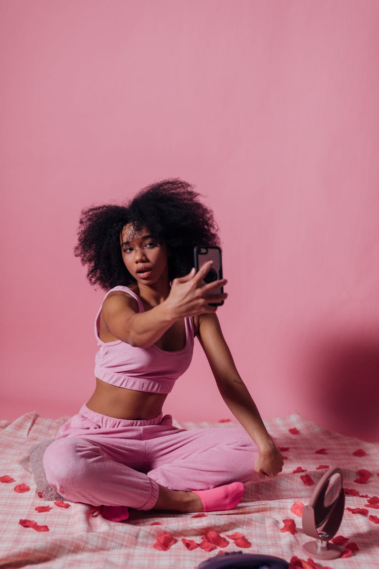 Woman In Pink Top And Jogging Pants Taking A Selfie