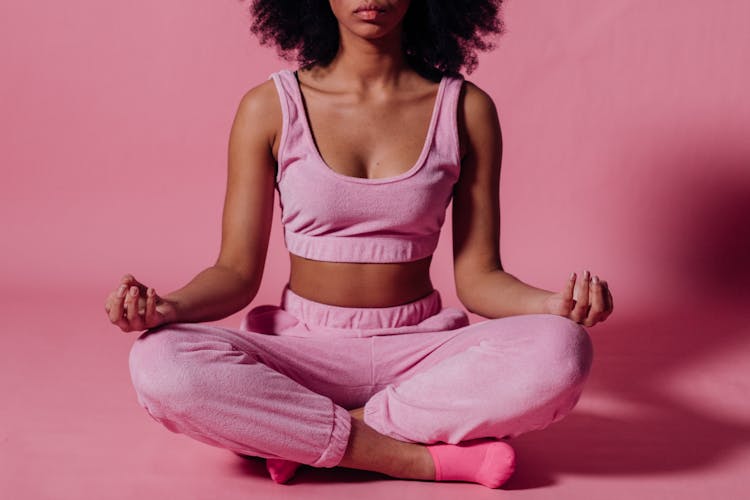 Woman In Pink Crop Top And Jogging Pants Practicing Yoga