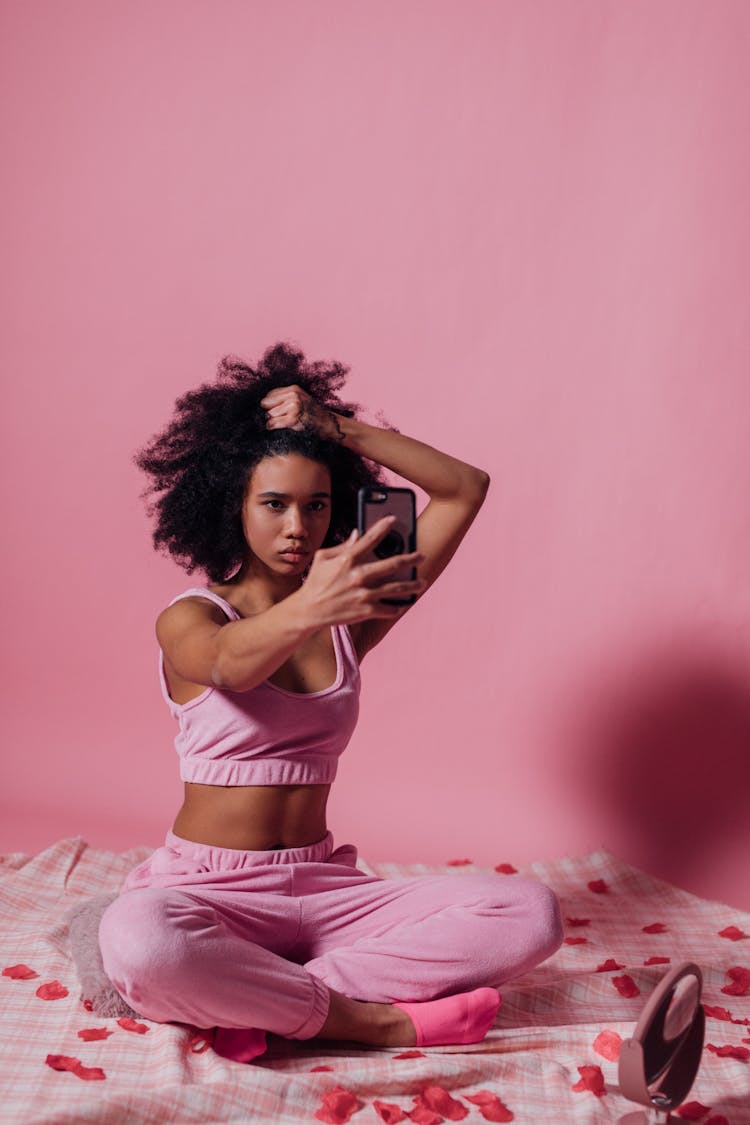 Woman In Pink Top And Jogging Pants Taking A Selfie