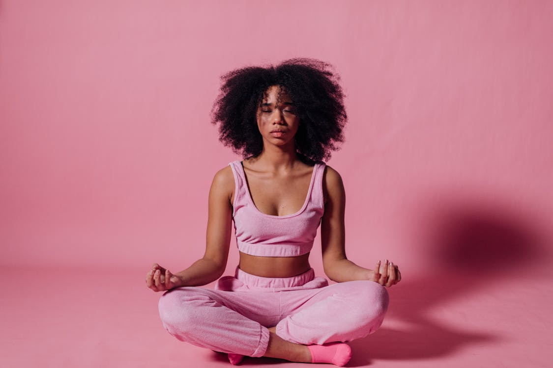 woman in pink crop top and jogging pants practicing yoga 