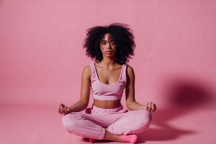 Woman In Pink Crop Top And Jogging Pants Practicing Yoga