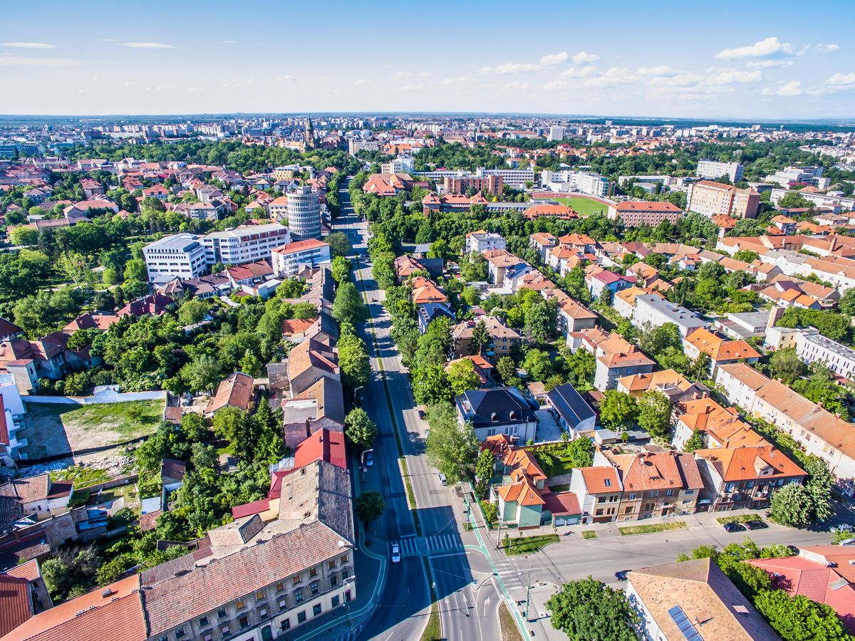 Arhitectura urbana si copaci vazute din aer, sub cer senin