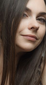 Close-up portrait of a woman with long brown hair, showcasing natural beauty.