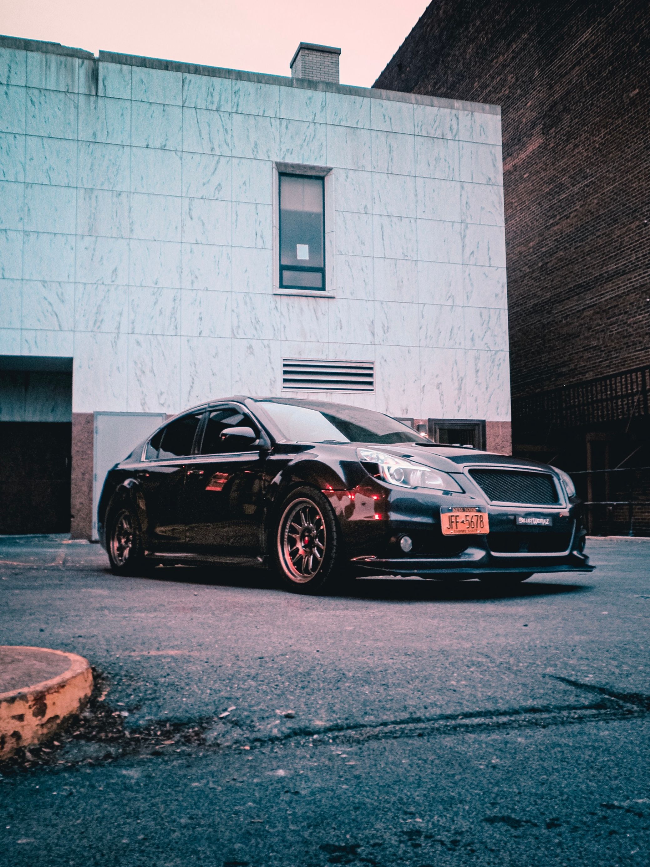 A Black Car Parked in Front of a Building · Free Stock Photo
