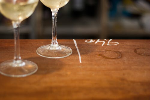 Free Close-Up Shot of Wine Glasses on Wooden Surface Stock Photo