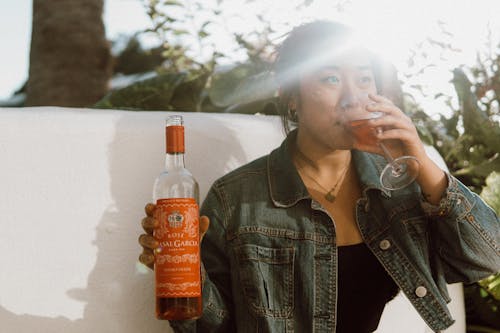 Woman in Blue Denim Jacket Drinking 