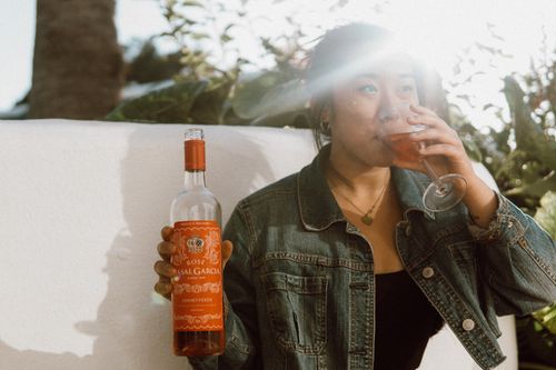 Free A woman savoring a glass of rosé wine in sunny outdoor setting, Portugal. Stock Photo