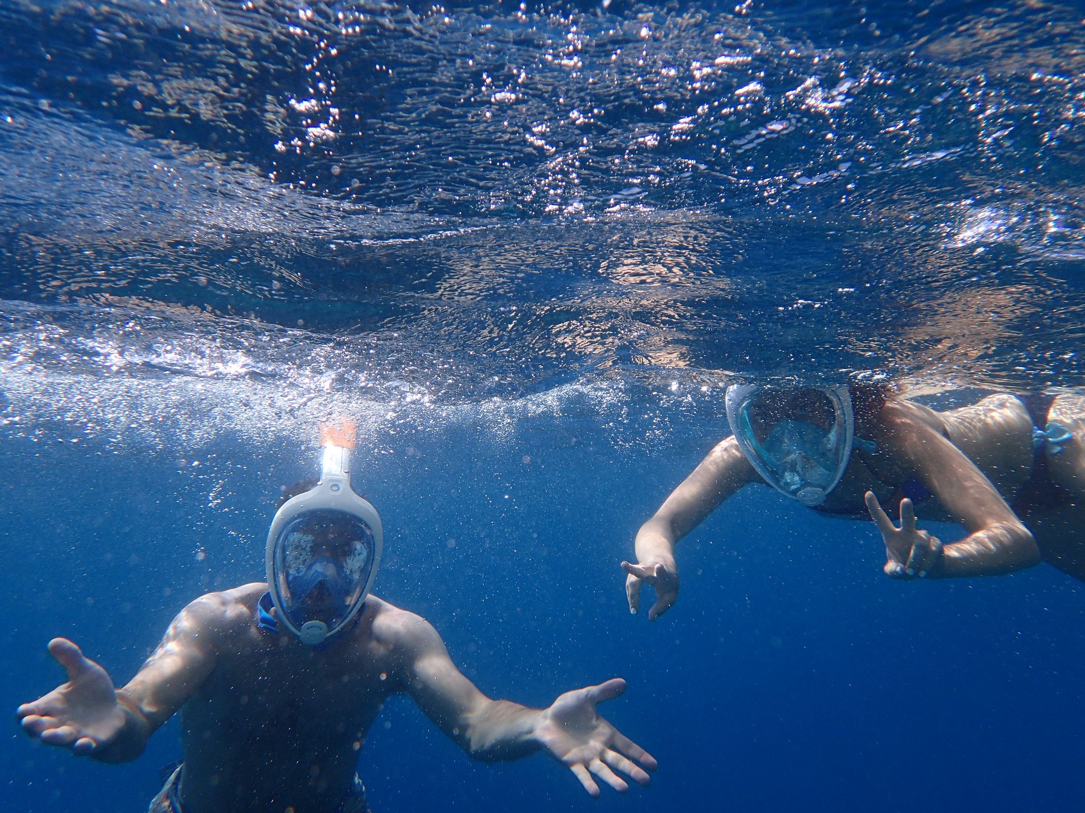 People snorkeling underwater in clear coastal water