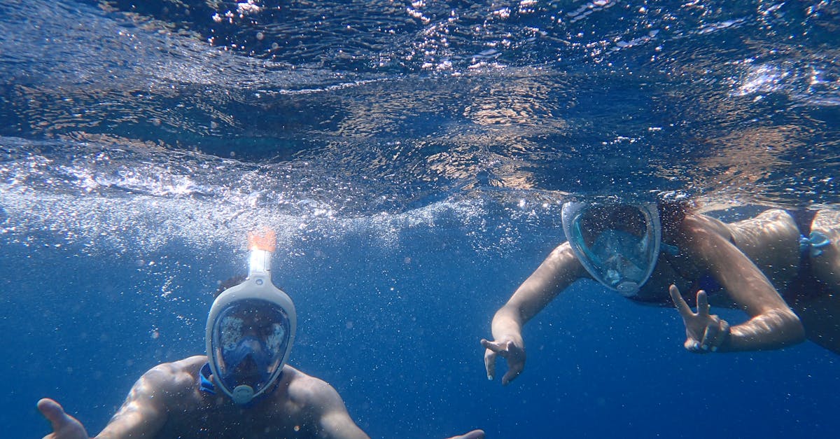 Two Man and Woman Wearing White Masks Swimming in Water