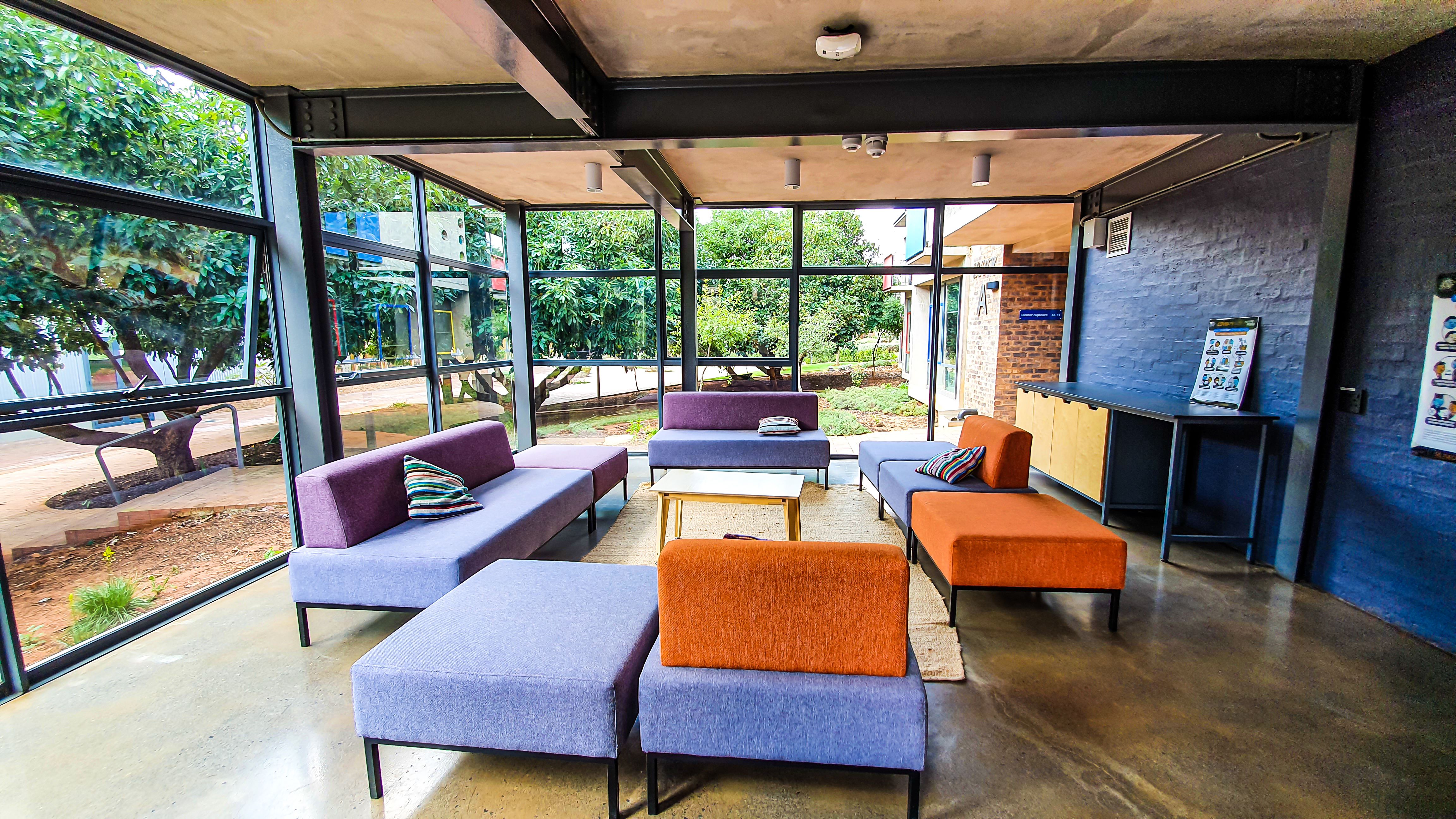 Vibrant living room with orange and purple sofas and colorful patterned cushions