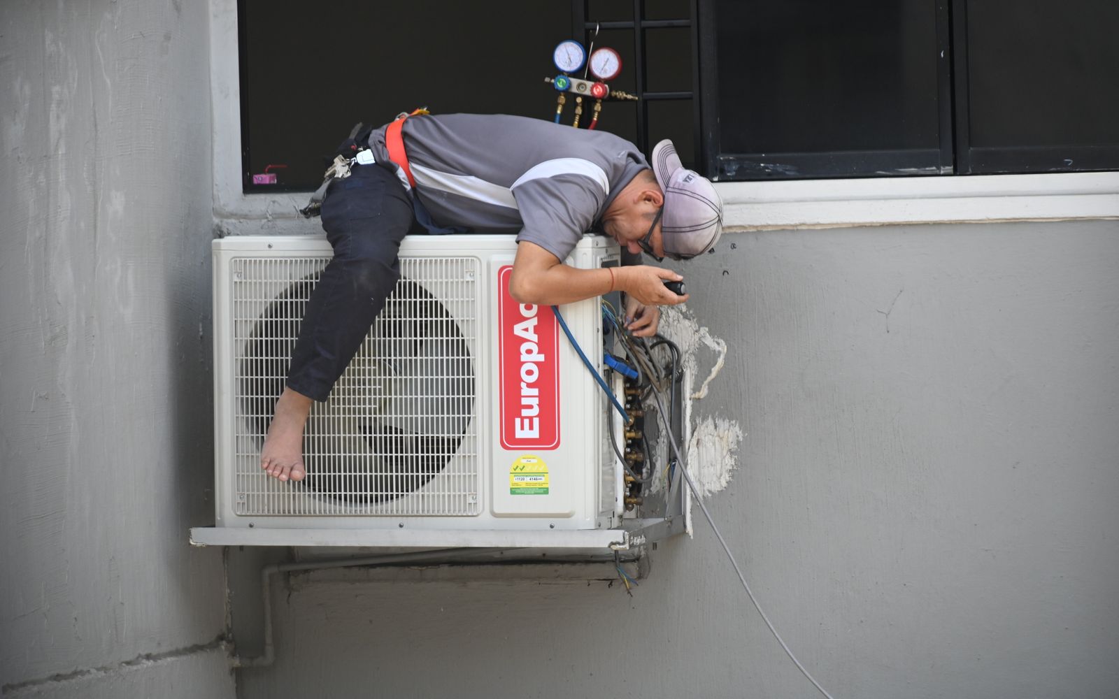 Technician repairing a commercial air conditioning unit in Dubai