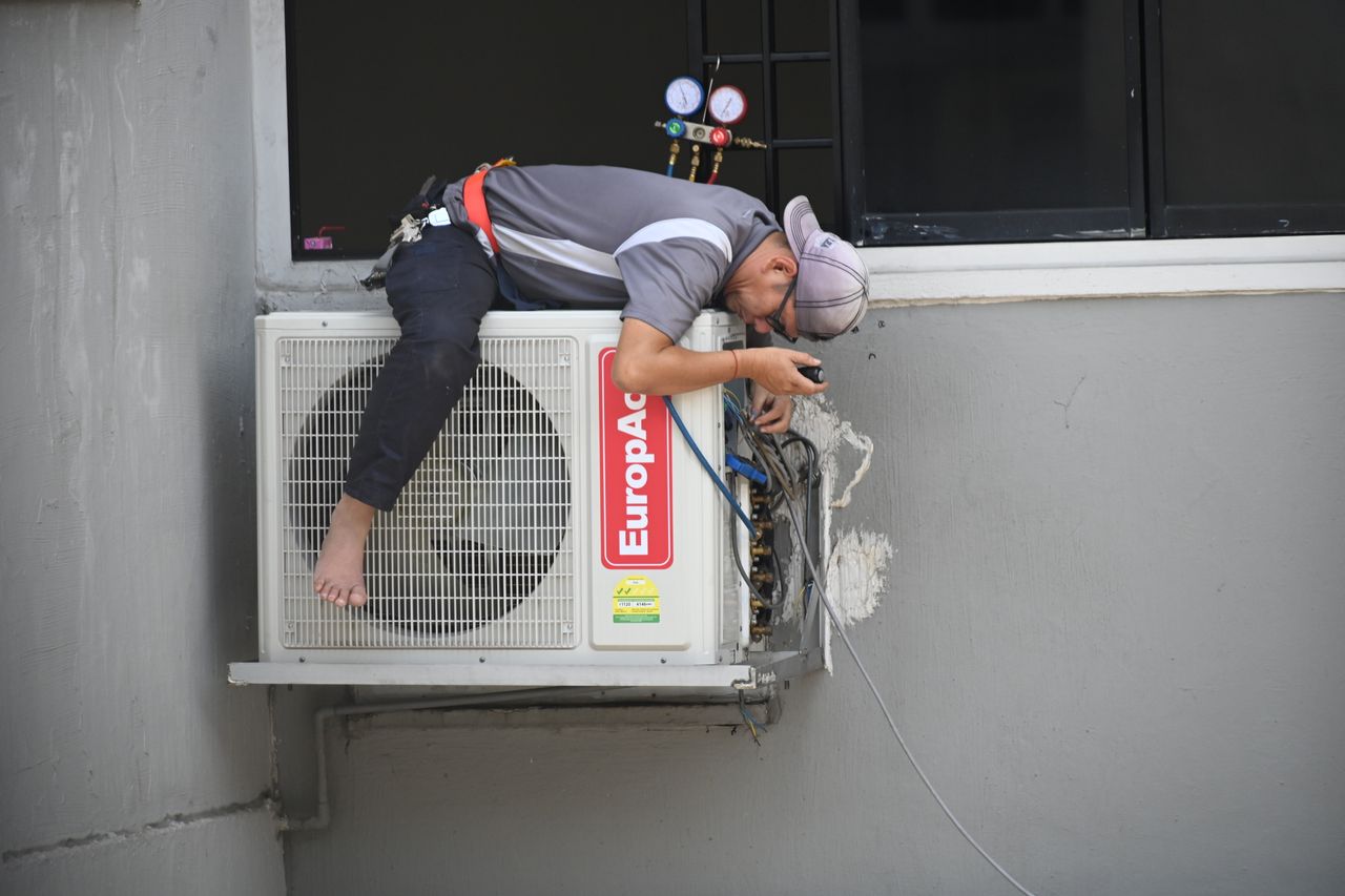 Hand holding an HVAC pressure gauge during a system check