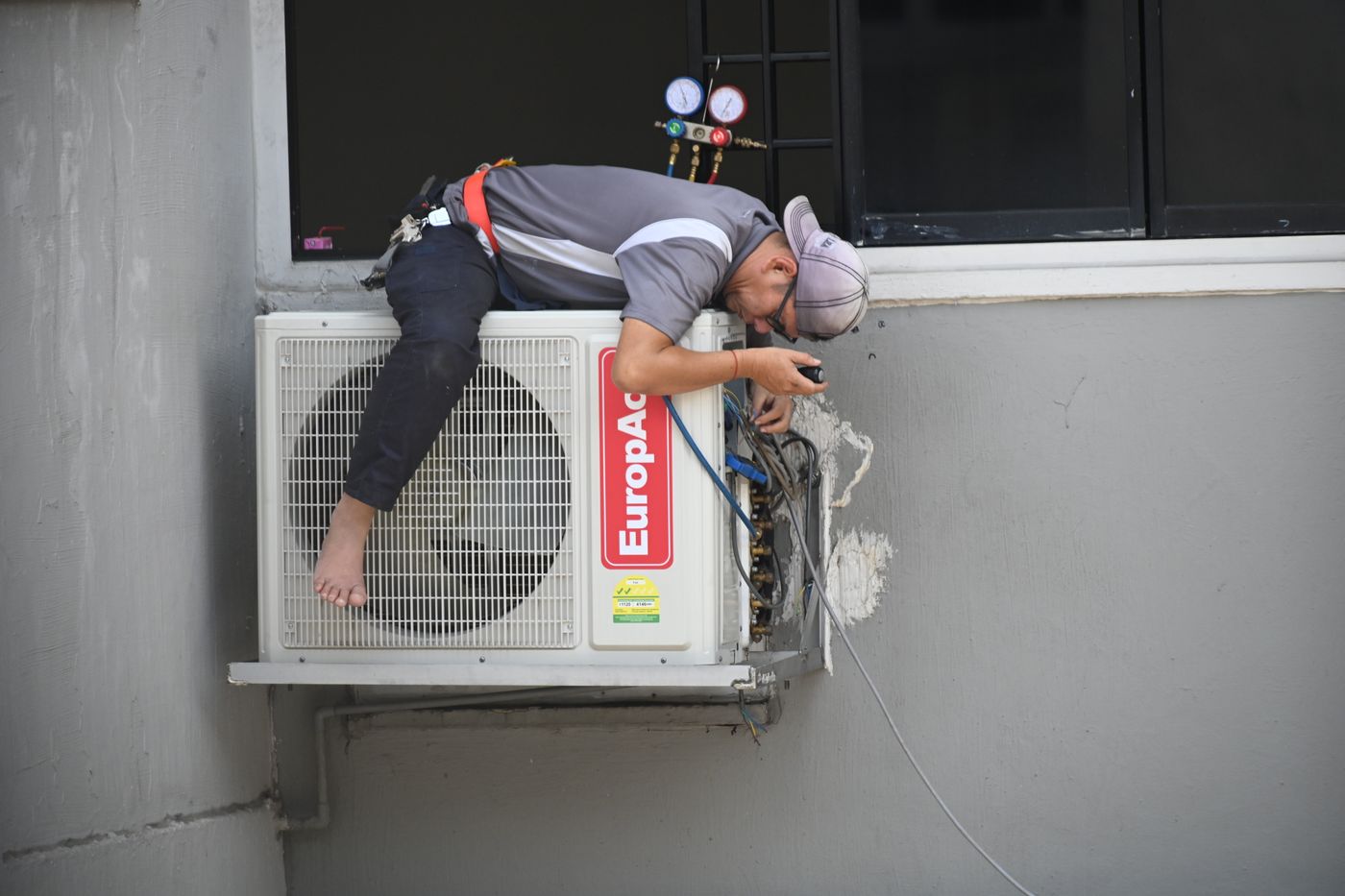 HVAC technician repairing an outdoor AC unit
