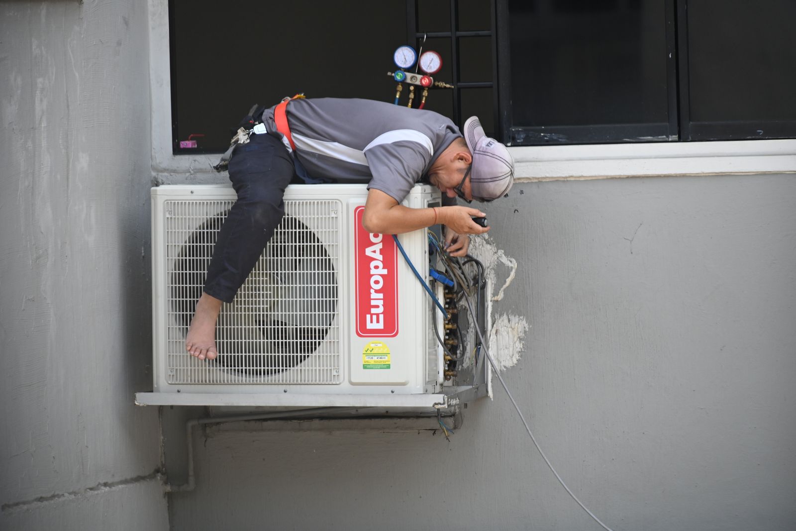 Technician membaiki sistem air conditioner