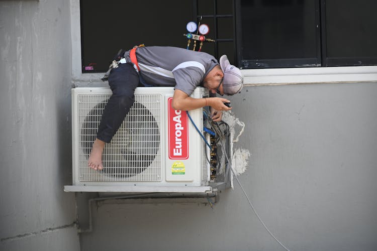 Man In Gray T-shirt Fixing The Aircon