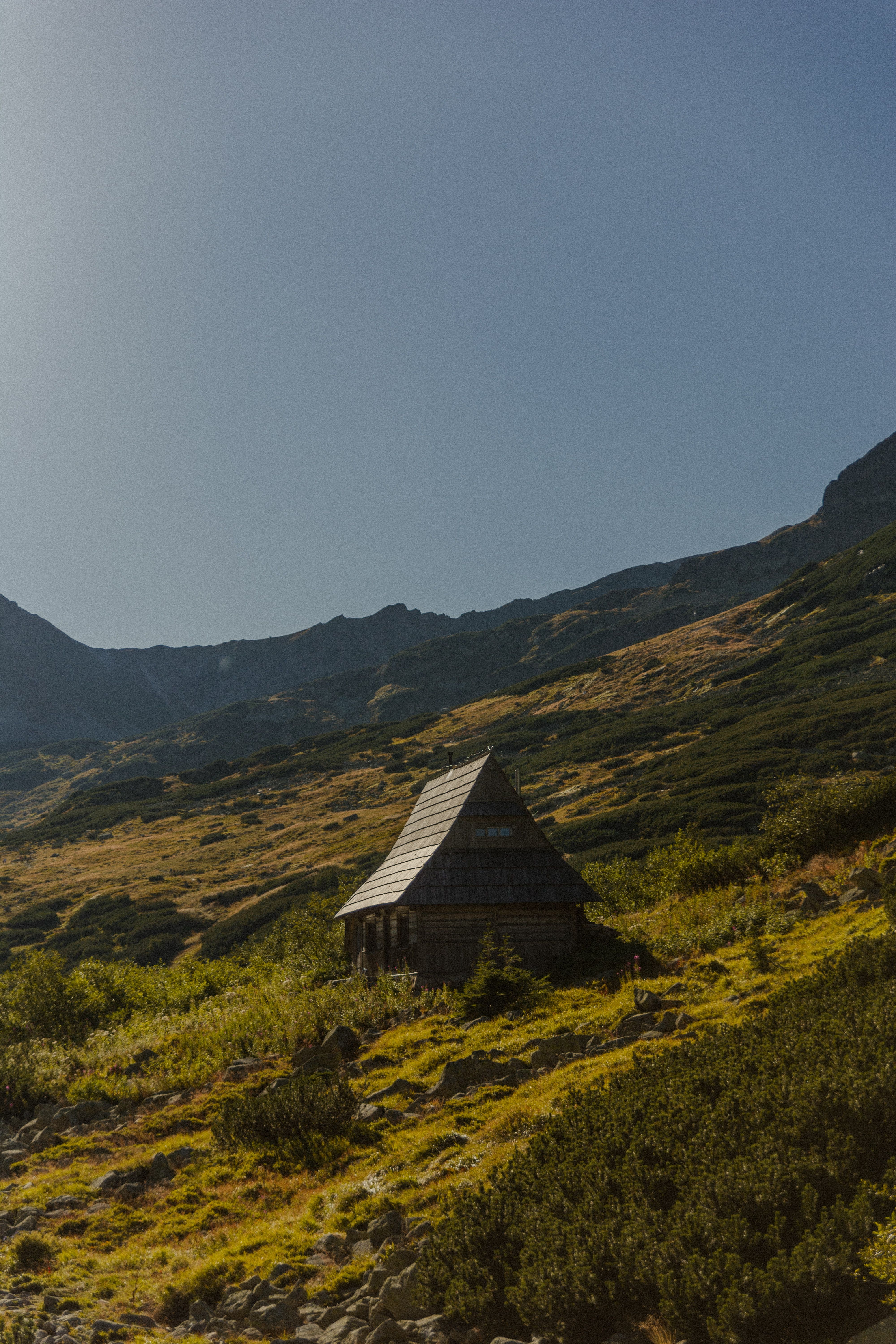 Brown Wooden House on Green Grass Field Near Mountain · Free Stock Photo