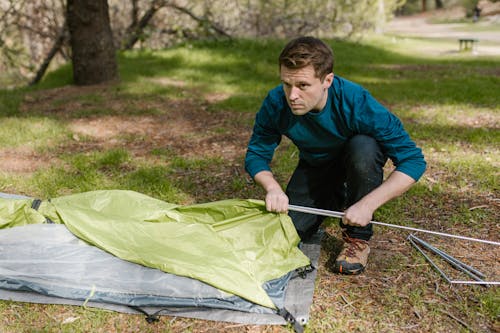 Free A Man Setting Up a Camping Tent Stock Photo
