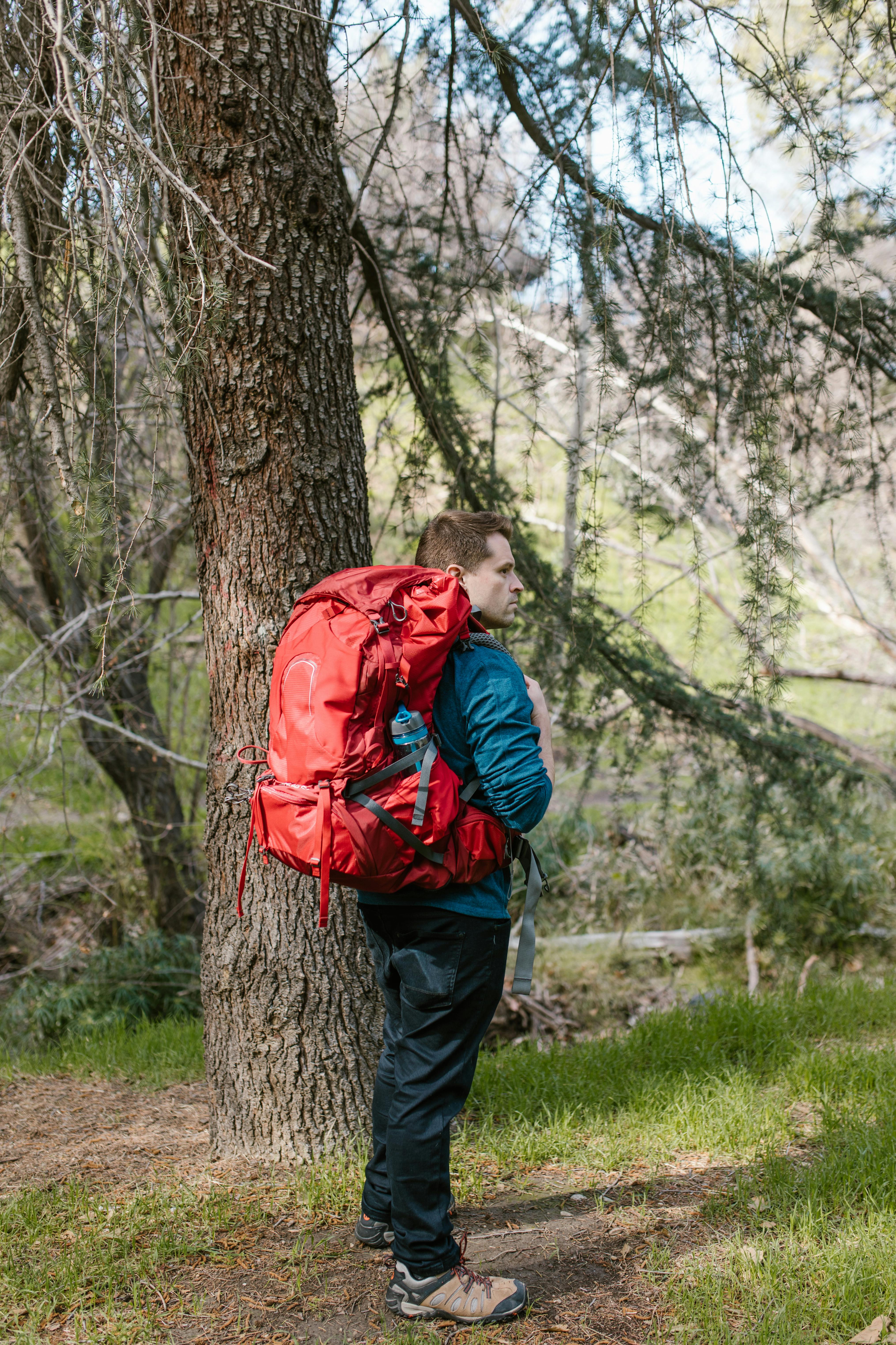 photo of a man with a red backpack camping