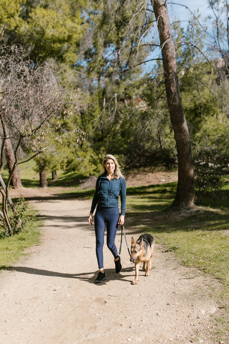 Photo Of A Woman Walking Her German Shepherd Pet