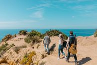 3 Women and 2 Men Standing on Brown Rock Formation