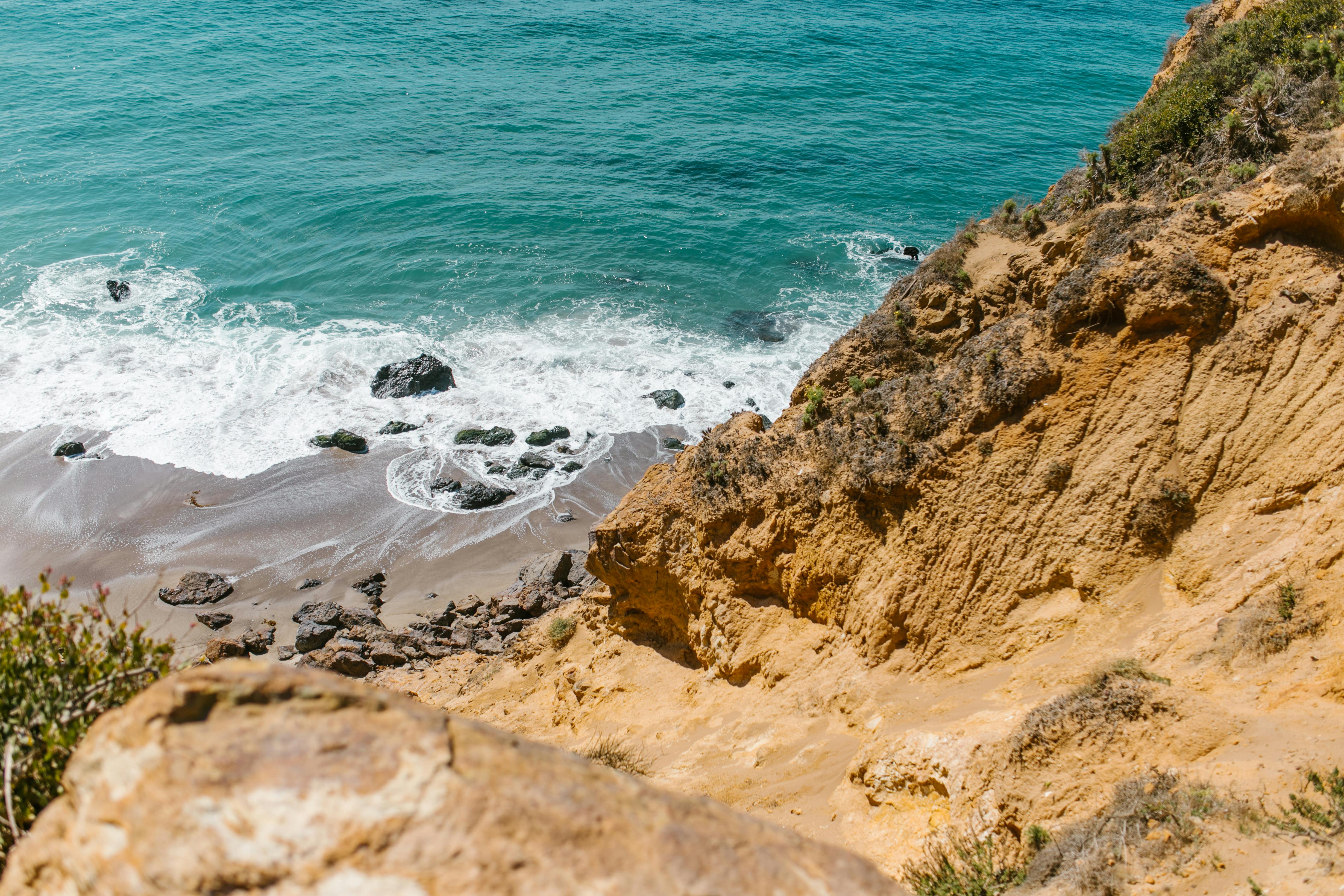 brown rocky shore near body of water