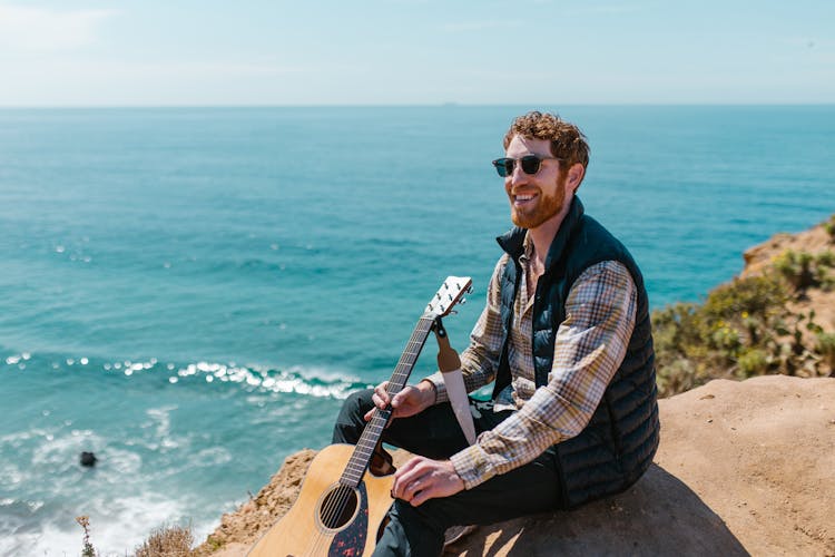 Photo Of A Man With Red Hair Holding A Guitar