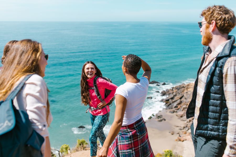 Vrienden wandelen bij een klif met uitzicht op zee