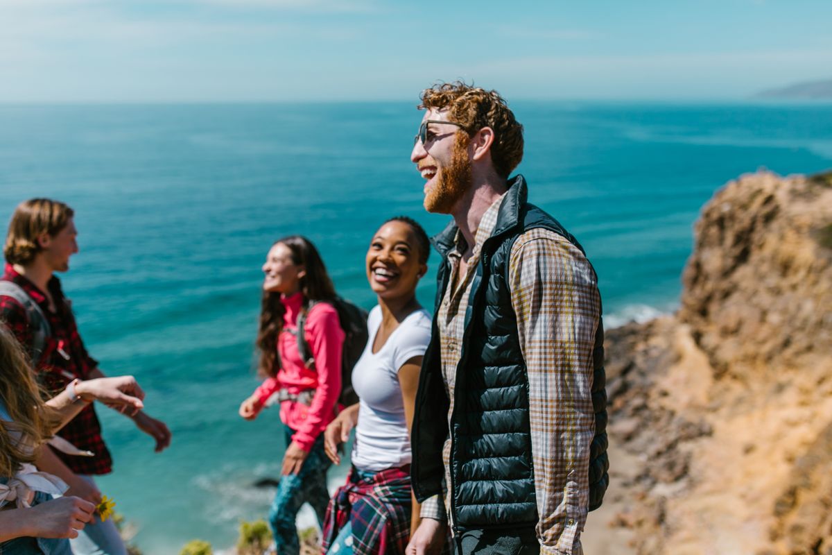 Group of friends laughing together by the sea