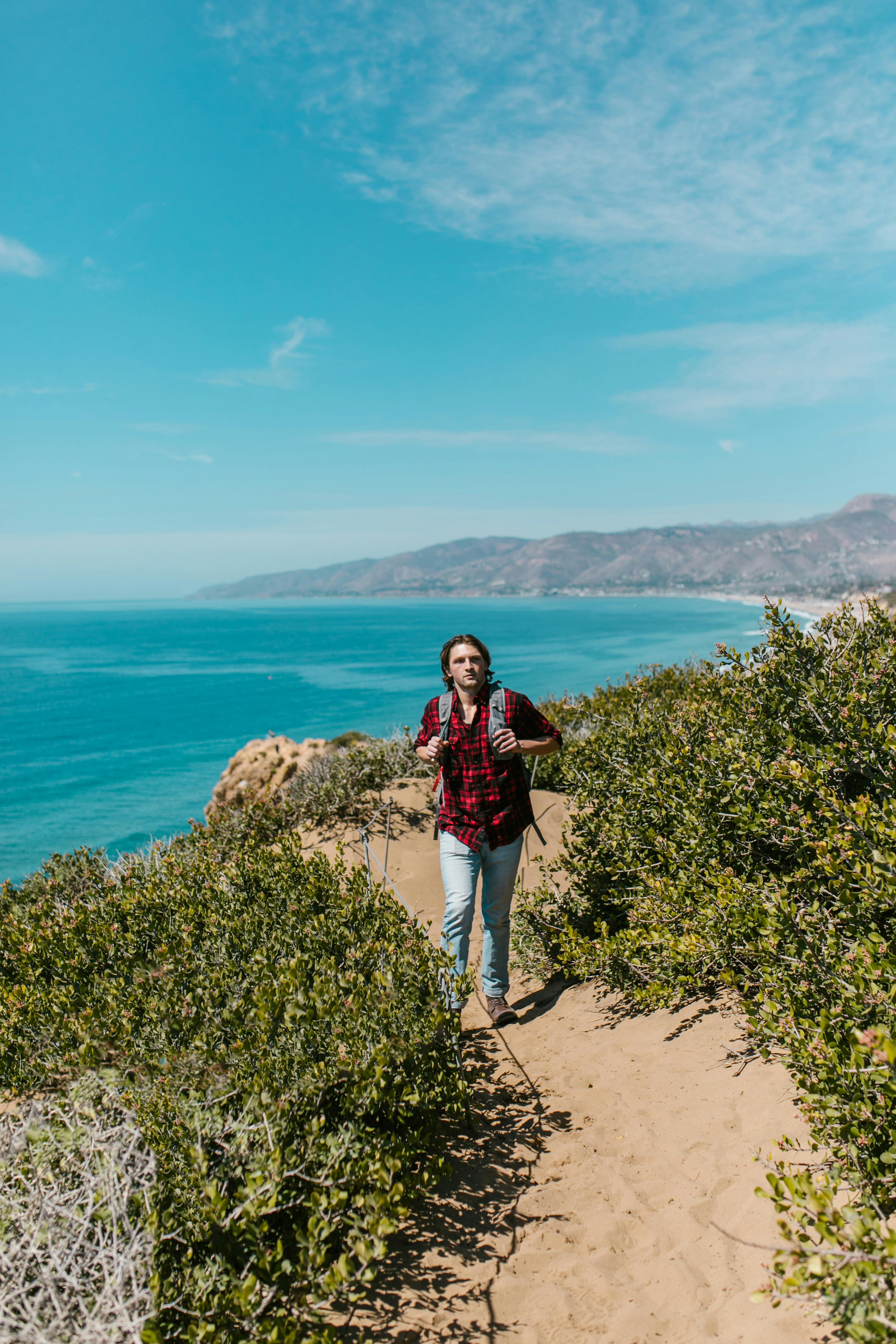 Person in Black Pants and Black Hiking Shoes Sitting on Rocky Shore  Free  Stock Photo