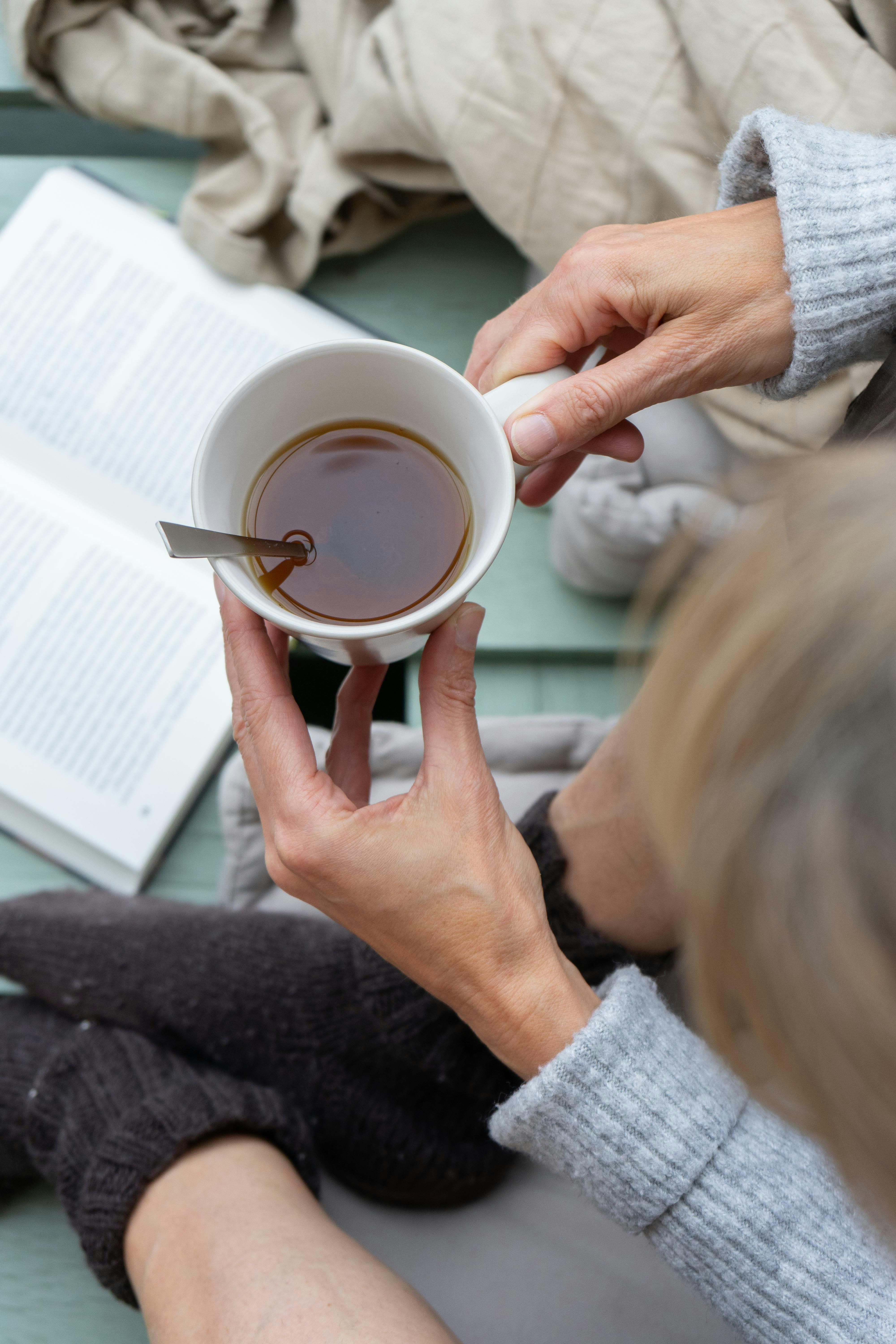 A serene moment with a ceramic mug of tea, warm socks, and an open book.