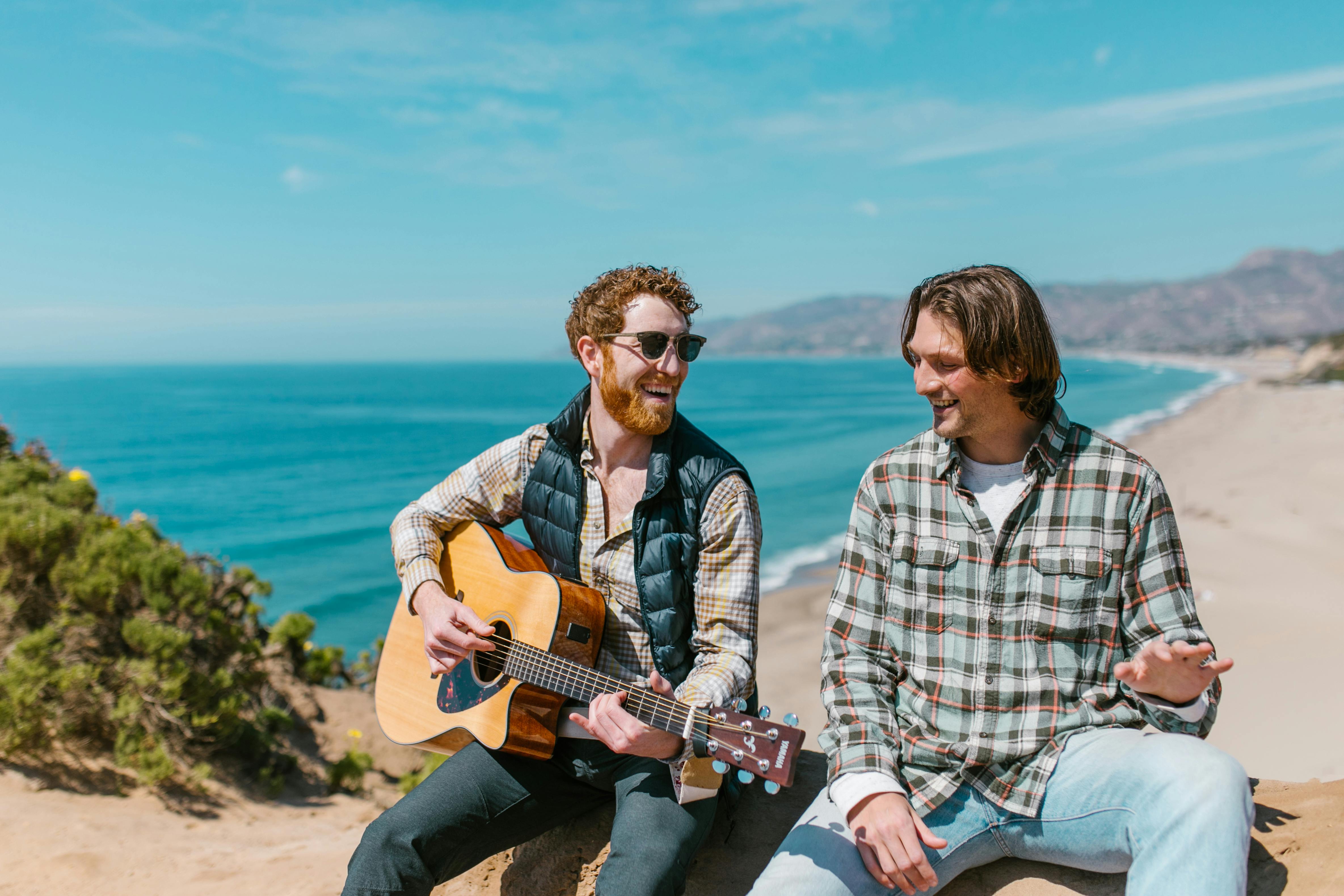 man and woman holding acoustic guitars