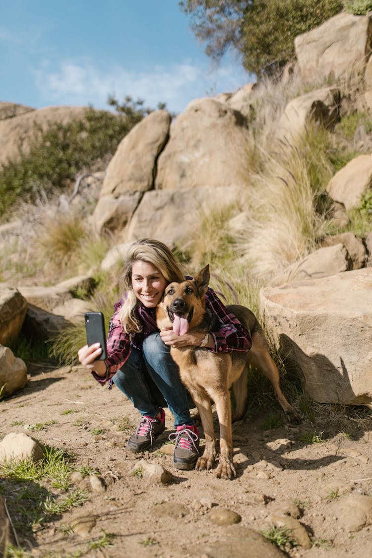 A Woman Taking Selfie With Her Pet Dog Using A Smartphone