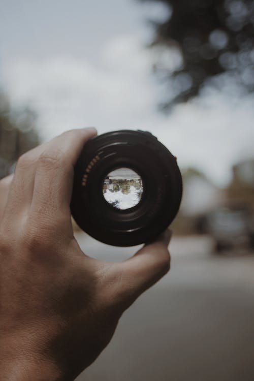 Close-up of a Man Holding a Camera Lens