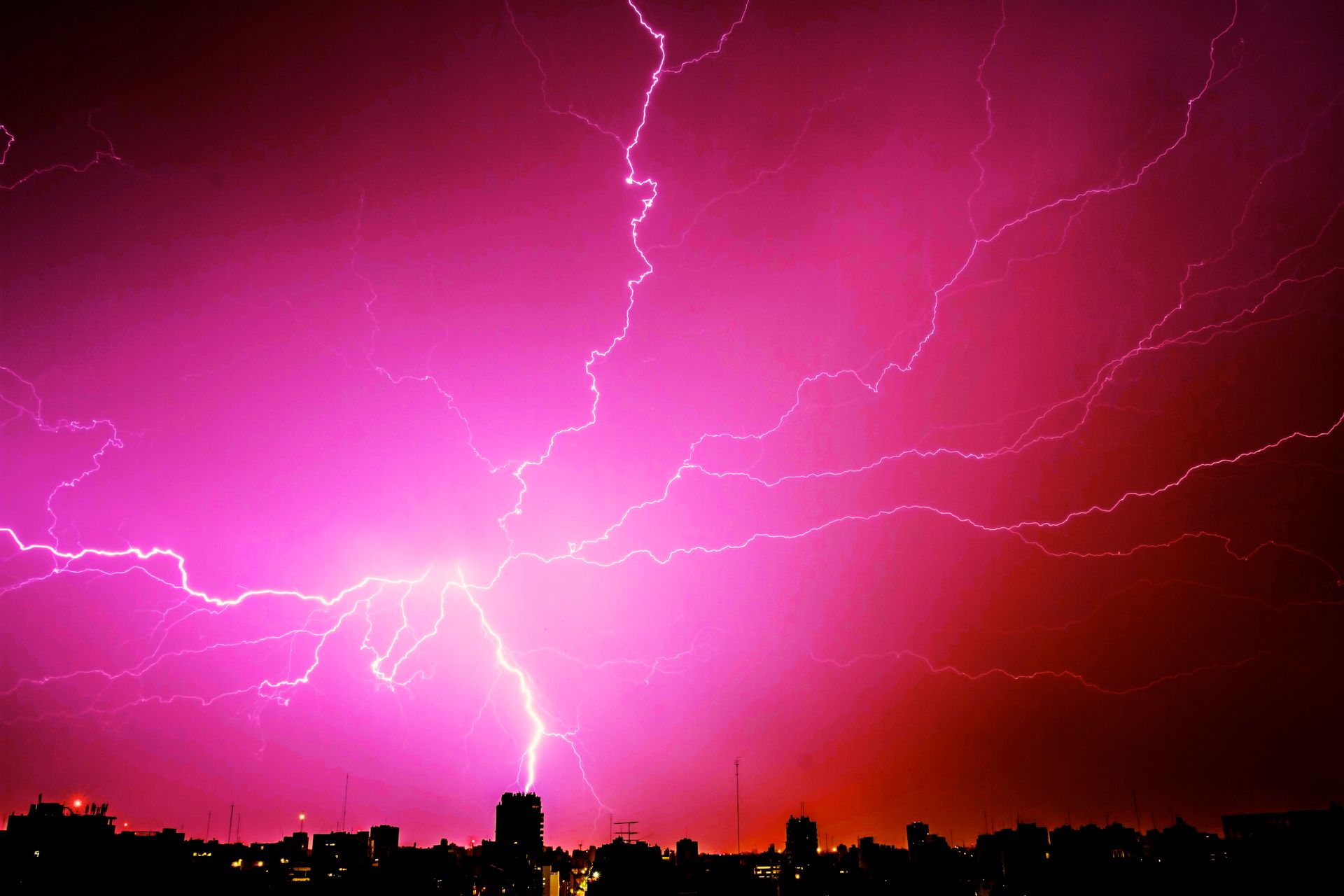 Spectacular lightning storm above Buenos Aires skyline at night, showcasing vibrant colors and dramatic energy.