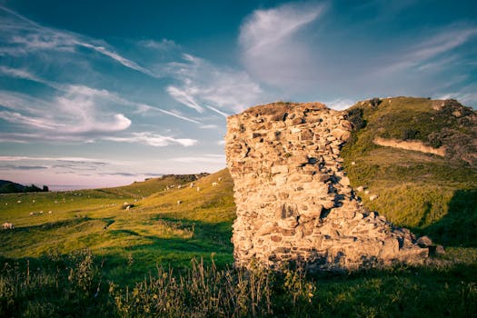 郁郁葱葱的绿色山丘中，古老的石头遗址矗立在蓝天下