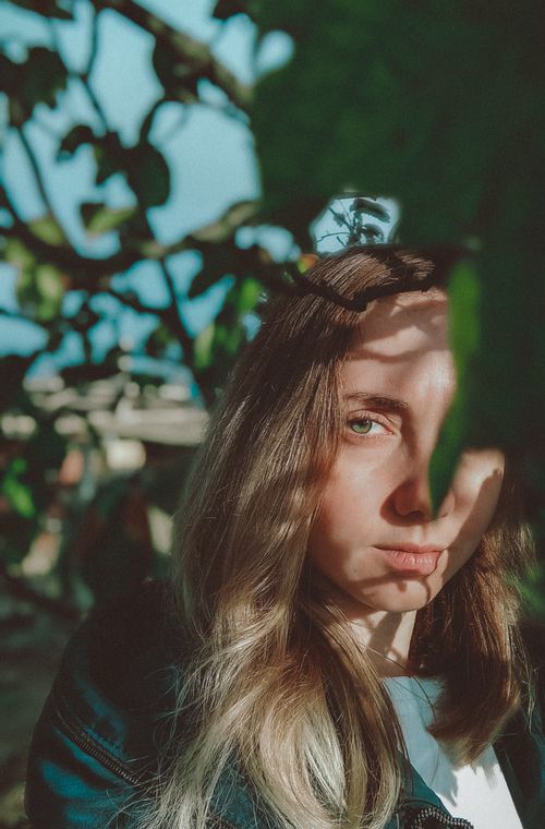Free Close-up of a young caucasian woman in natural lighting, highlighting her blonde hair and thoughtful expression. Stock Photo