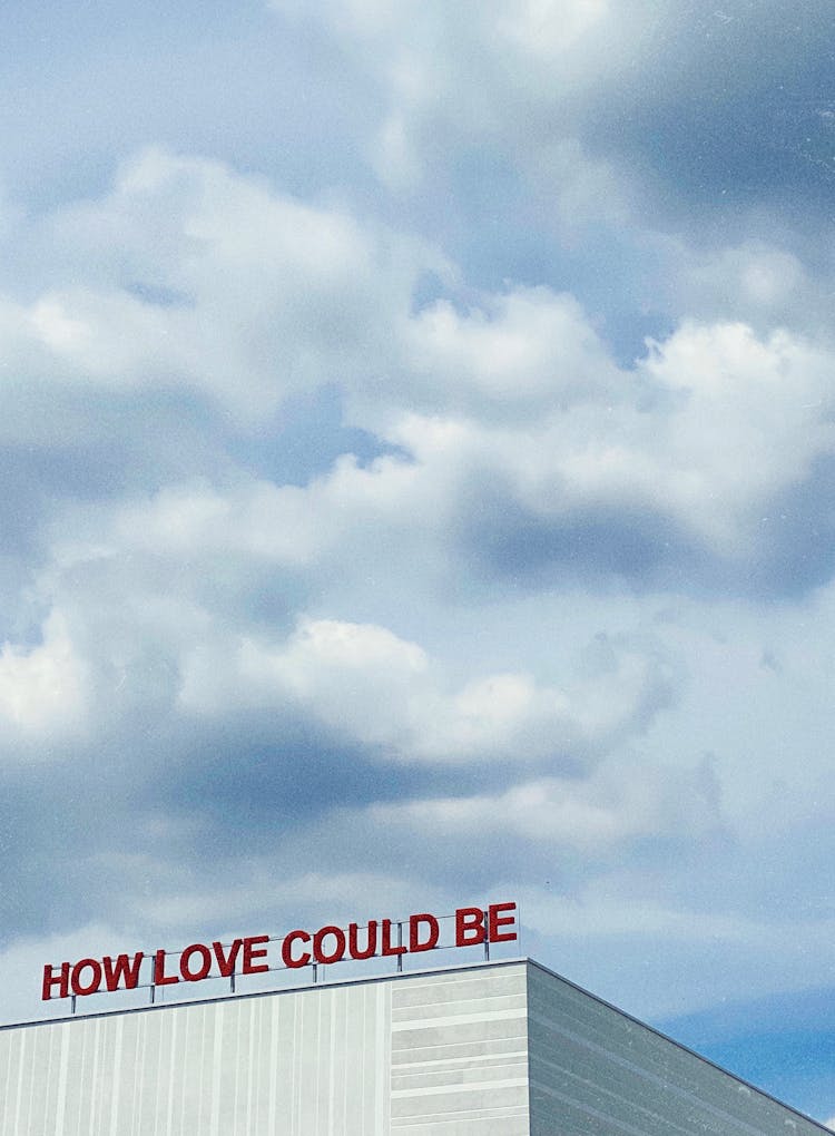 Building Roof With Signage Under White Clouds 