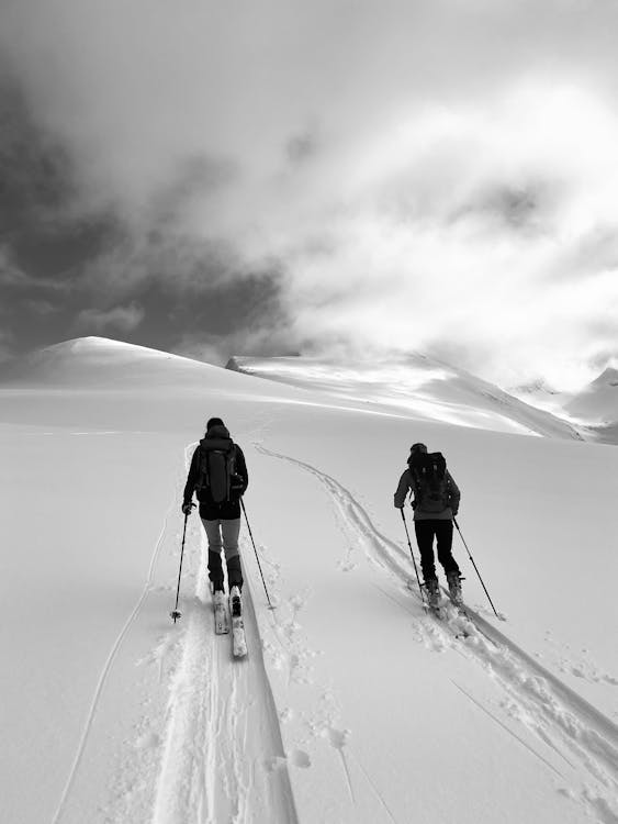 Two People Hiking on a Snow Covered Hill