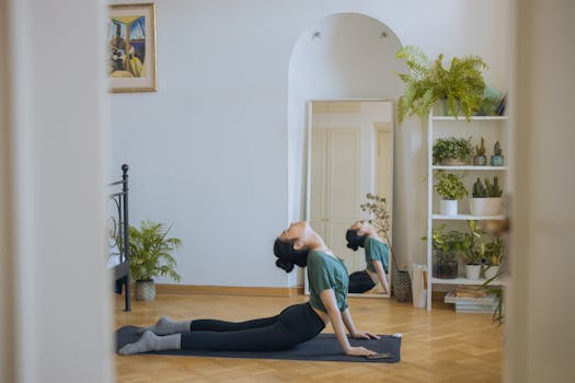 Asian woman practicing yoga pose at home, embodying wellness and relaxation in a serene indoor setting.