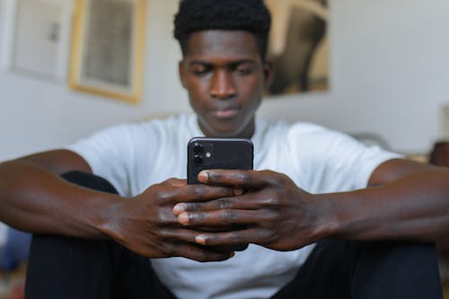 Man Wearing White Shirt Holding Smartphone