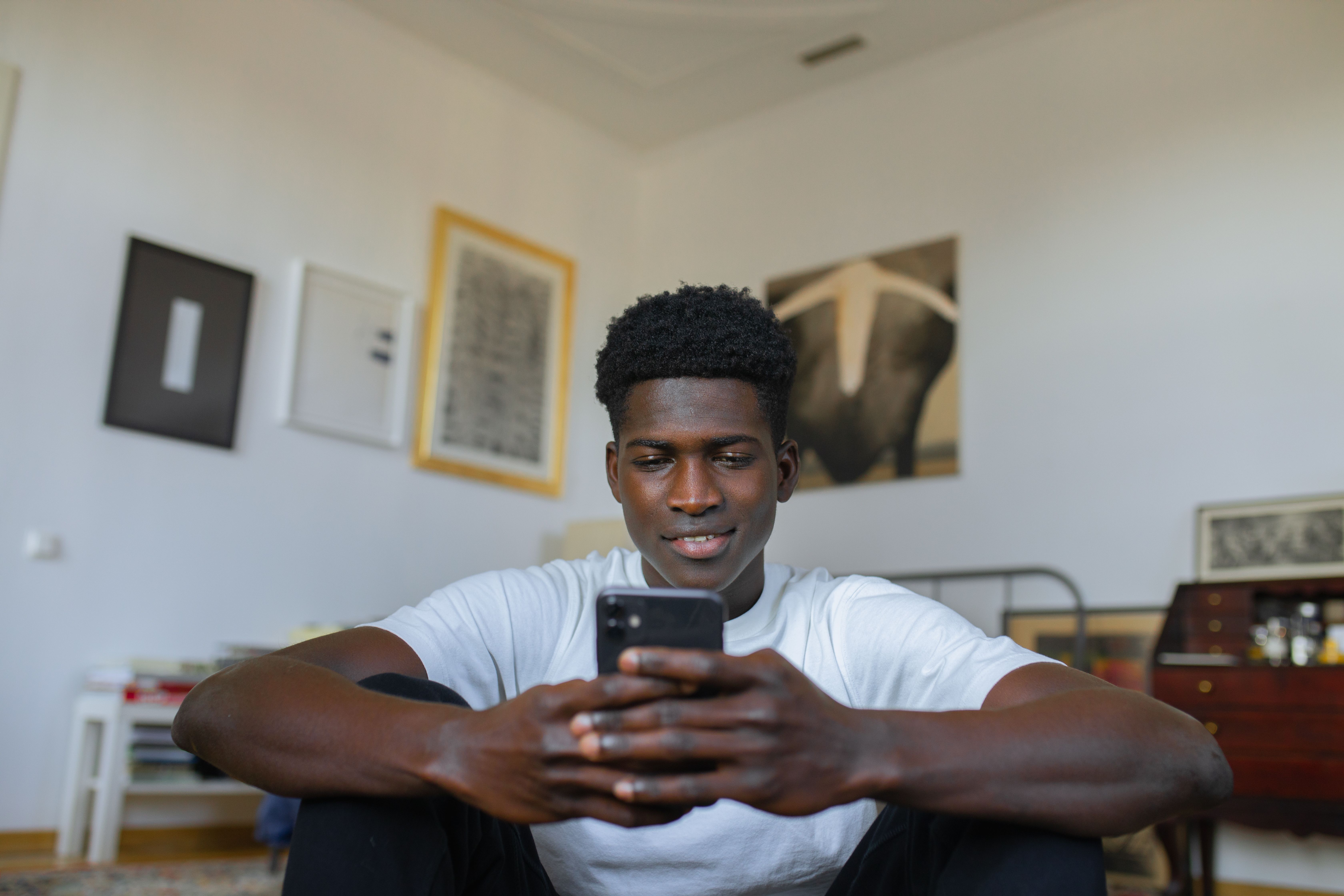A person using a smartphone to browse an online art gallery featuring unusual and thought-provoking artwork.