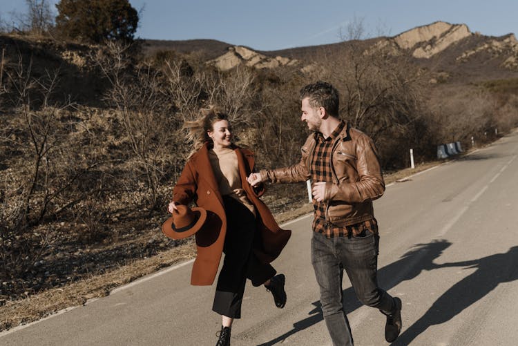 Happy Couple Running On The Asphalt Road