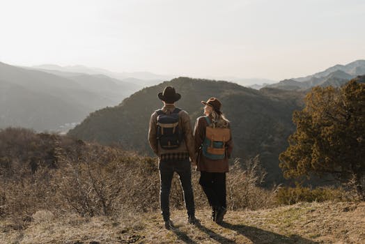 Couple holding hands and enjoying a scenic mountain view during a day hike.