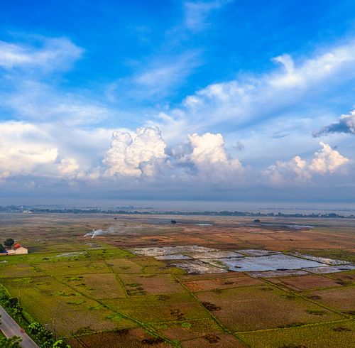 Free Vibrant aerial shot of Banten's farmland under a bright blue sky. Stock Photo