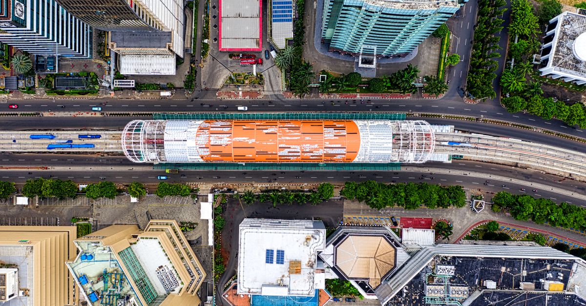 Top view of a busy railway station in Jakarta showcasing urban architecture.