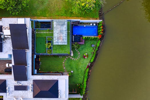Aerial view showcasing a modern waterfront mansion with a pool and garden in Tangerang, Indonesia.