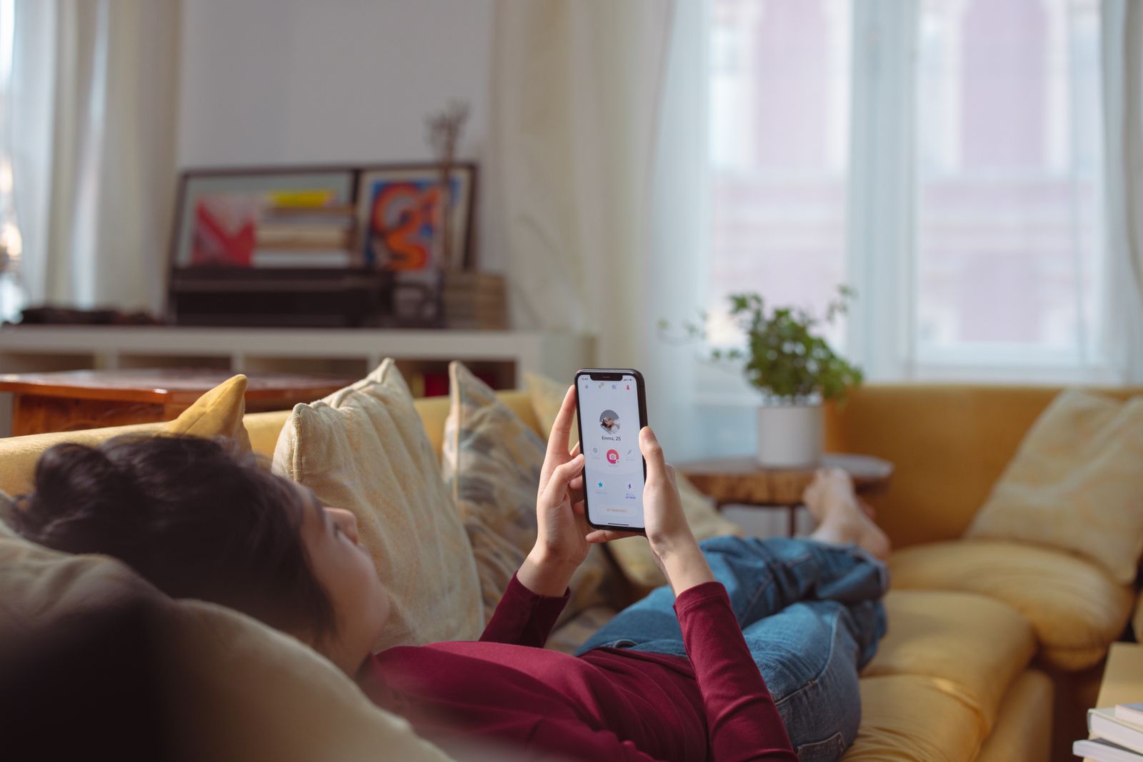 Personne tenant un smartphone affichant une application de rencontre avec interface de profils