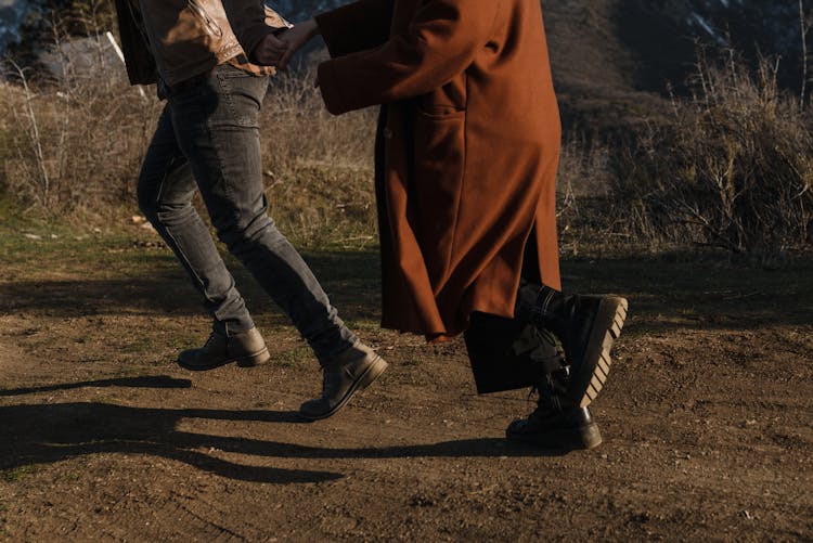 Couple Holding Hands Running On The Ground